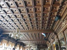 Detalle arquitectónico del techo de madera tallada en el salón principal