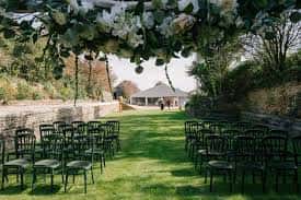 Configuración de ceremonia al aire libre con sillas y decoración floral