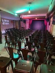 Sala principal con patio de butacas y escenario con telón rojo