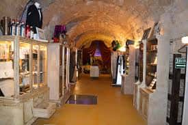 Galería del museo de la magia con vitrinas y techos de bóveda de piedra