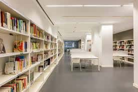 Vista interior de la sala de estudio con estanterías modernas y zonas de lectura