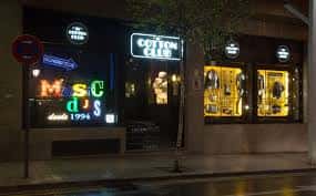 Vista exterior nocturna de la entrada del Cotton Club Bilbao con sus icónicos letreros de neón