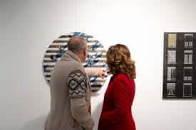 Visitantes observando obras de arte en la Sala Patricio