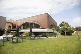 Vista de los jardines exteriores con mesas y sombrillas para eventos al aire libre