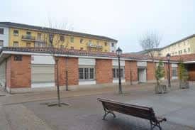 Fachada exterior de ladrillo del Centro Social de Ventanielles con plaza y mobiliario urbano