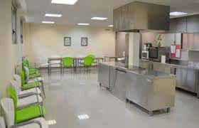 Interior del Centro Social de Ventanielles con zona de cocina y mesas de trabajo