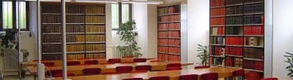 Sala de biblioteca y estudio con estanterías de libros y mesas de trabajo