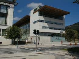 Edificio de arquitectura moderna con fachada blanca y gran voladizo de madera