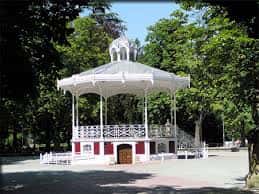 Vista frontal del emblemático quiosco de música de estilo clásico y estructura blanca