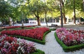 Senderos sombreados y cuidados jardines con flores de temporada en el parque