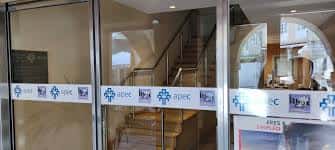 Vista del vestíbulo y escaleras de acceso a través de la entrada acristalada de APEC Lugo