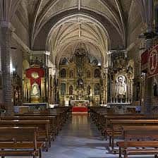 Perspectiva del interior de la iglesia mostrando la nave central y el retablo mayor