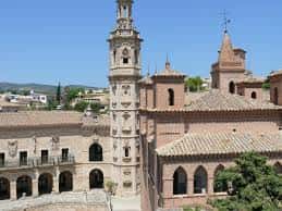 Plaza con torre de estilo mudéjar y galerías porticadas tradicionales