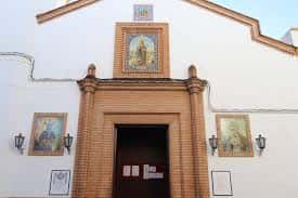 Detalle de la puerta principal con mosaicos cerámicos de imágenes religiosas
