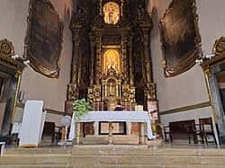 Perspectiva del altar mayor y el retablo barroco en el interior del templo