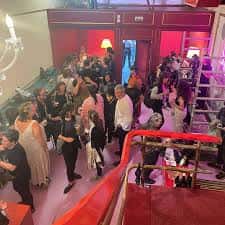 Interior del centro cultural durante un evento con público y vista de la escalera principal