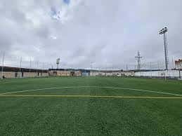 Vista panorámica del terreno de juego de césped artificial bajo un cielo nublado