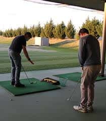Jugadores practicando el swing en la zona de tiro exterior