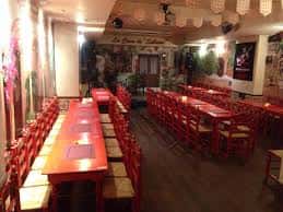 Interior del local con mesas y sillas dispuestas para eventos y actuaciones