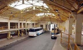 Perspectiva amplia del interior de la estación mostrando la estructura metálica del techo y la zona de tránsito