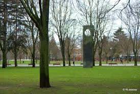 Escultura moderna situada en una amplia zona verde del parque