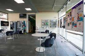 Interior del centro con zona de descanso, mesas y paneles informativos