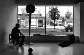 Vista del interior de la galería con un gran ventanal hacia el exterior en blanco y negro