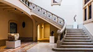 Escalinata de piedra con barandilla de hierro forjado en el interior del museo