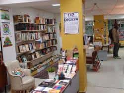 Interior de la librería con estanterías repletas de libros y un rincón de lectura con sillón