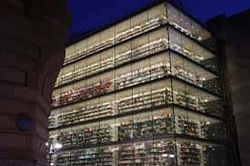 Vista nocturna de la fachada de cristal de la Biblioteca Foral de Bizkaia con las estanterías iluminadas