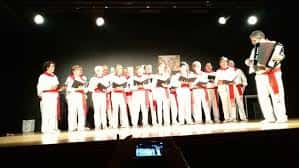 Actuación del coro en el escenario del salón de actos del Hogar Navarro