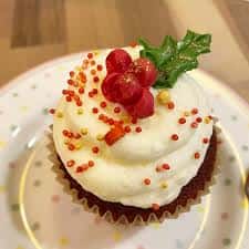 Cupcake decorado con crema blanca y detalles de acebo