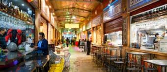 Pasillo interior del mercado con puestos de gastronomía y ambiente local