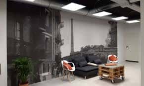 Zona de descanso con sofás y un mural decorativo de la antigua fábrica