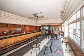 Interior de un local comercial con barra de madera y zona de mesas en las Galerías Viacambre