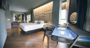 Interior de una habitación moderna con cama doble, zona de escritorio y decoración contemporánea