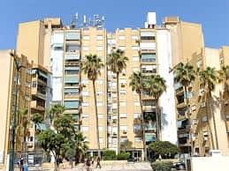 Fachada de edificio residencial con palmeras en la Calle Argéntea
