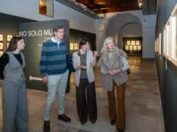 Interior de la sala de exposiciones con arquería antigua y obras de arte