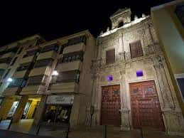 Vista nocturna de la fachada principal iluminada artísticamente