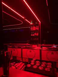 Vista de la barra de bebidas iluminada por luces rojas lineales