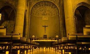 Interior del templo iluminado con velas durante la celebración de un evento