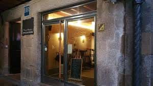 Entrada exterior del café con fachada de piedra tradicional