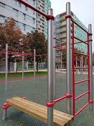 Detalle de las barras de tracción y banco de ejercicios en la zona deportiva