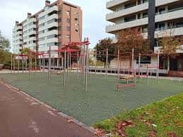 Área de entrenamiento funcional con equipamiento metálico y suelo de seguridad