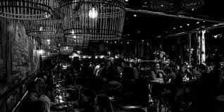 Ambiente nocturno en la zona de bar con lámparas de diseño colgantes