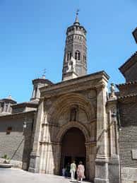 Vista de la torre mudéjar y la portada principal de la Iglesia de San Pablo bajo un cielo despejado