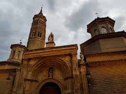 Perspectiva exterior de la iglesia mostrando el cimborrio y la torre en un plano más amplio