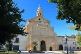 Vista exterior de la iglesia y el campanario de la Cartuja de la Inmaculada Concepción bajo un cielo despejado