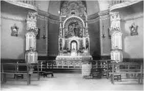 Vista del interior de la capilla con el altar mayor y los bancos para los fieles