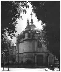 Fachada exterior de la capilla con su cúpula característica vista entre la vegetación